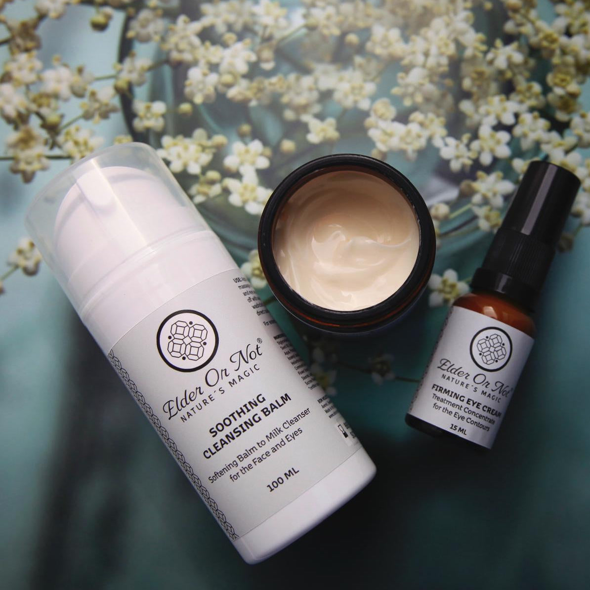 Three skincare products on a textured surface with floral background